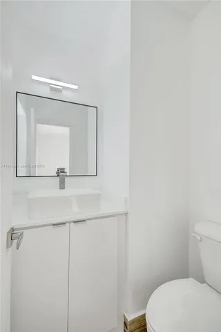 a bathroom with a toilet a sink and mirror