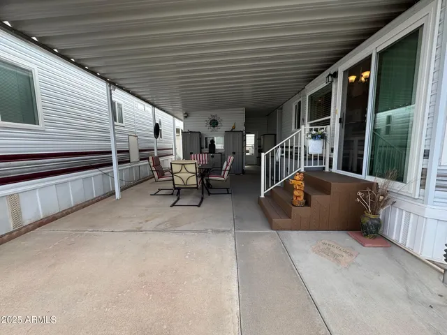 a view of a patio with table and chairs with wooden floor and fence