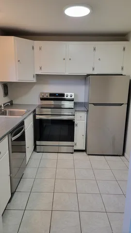 a kitchen with cabinets and steel appliances