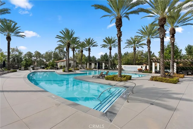 a view of a swimming pool with a lounge chair and palm trees