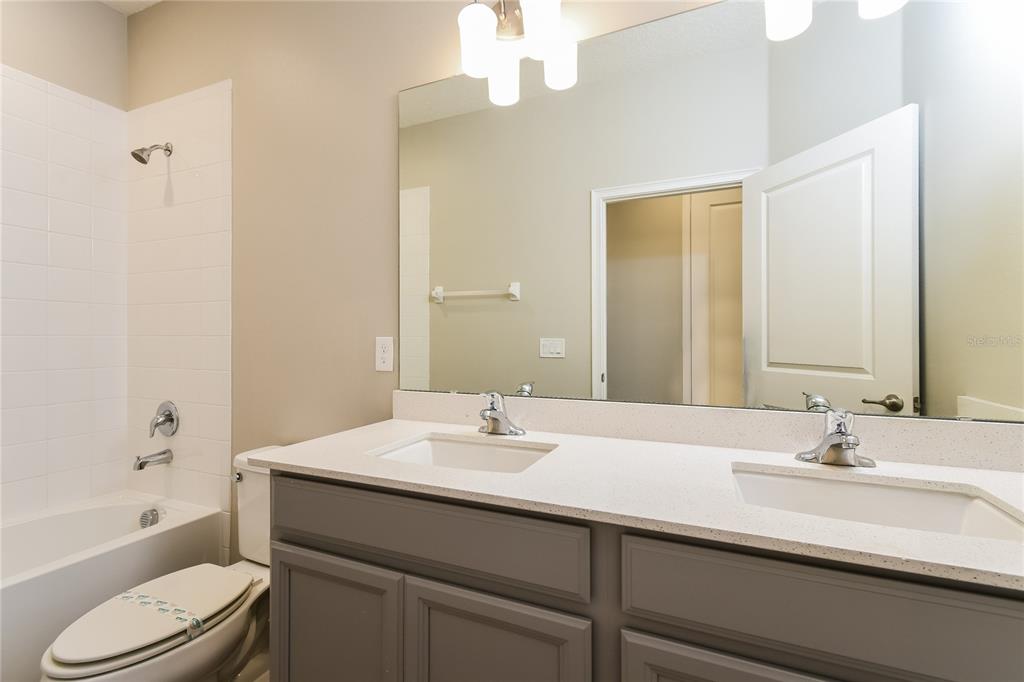 1073 Hendon Loop Davenport, FL 33837 - Photo 13 of 15 a bathroom with a sink a toilet and a large mirror