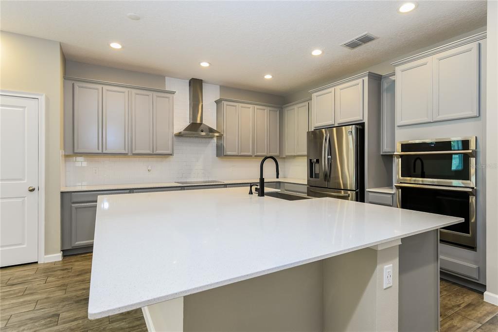 1073 Hendon Loop Davenport, FL 33837 - Photo 4 of 15 a kitchen with stainless steel appliances a refrigerator sink and microwave