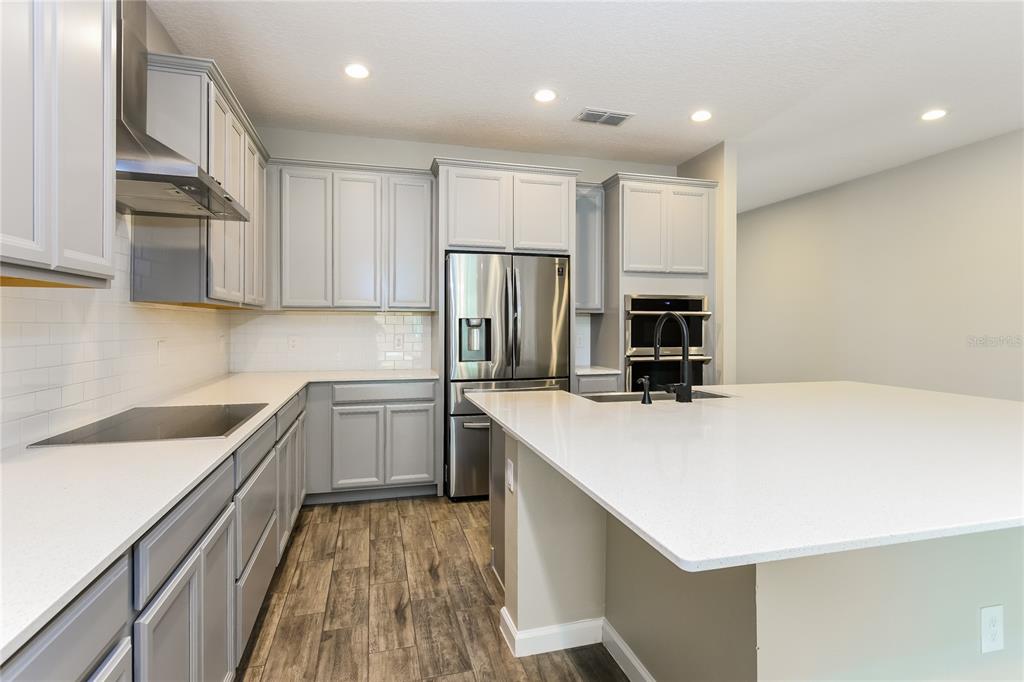 1073 Hendon Loop Davenport, FL 33837 - Photo 5 of 15 a kitchen with a sink a counter top space stainless steel appliances and cabinets