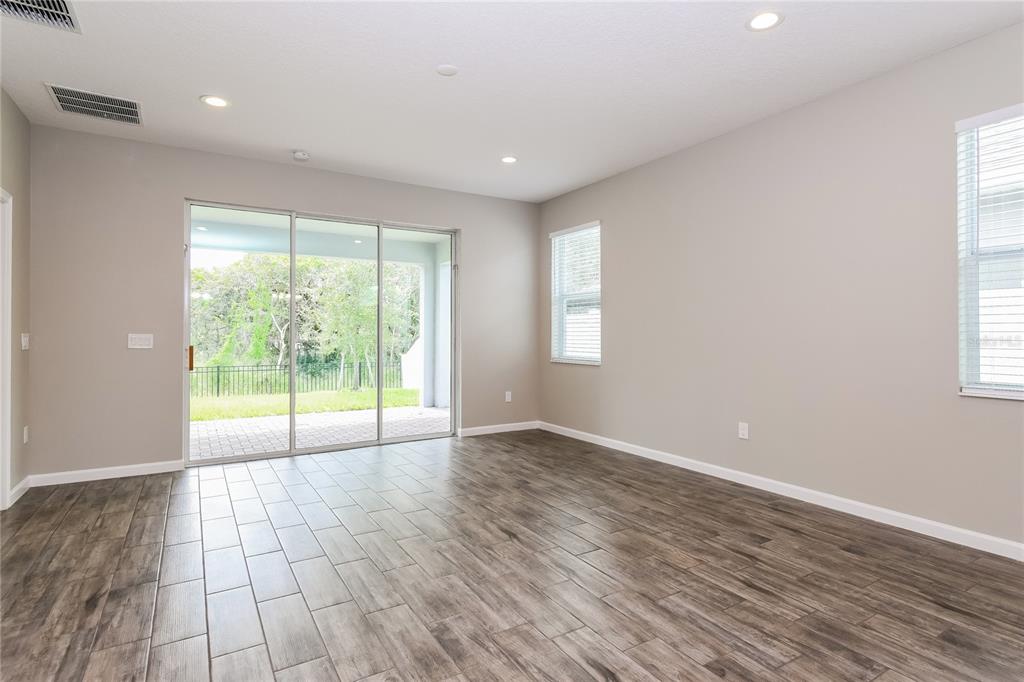 1073 Hendon Loop Davenport, FL 33837 - Photo 7 of 15 a view of an empty room with wooden floor and a window