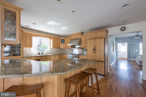 a kitchen with stainless steel appliances granite countertop a stove and a wooden floors