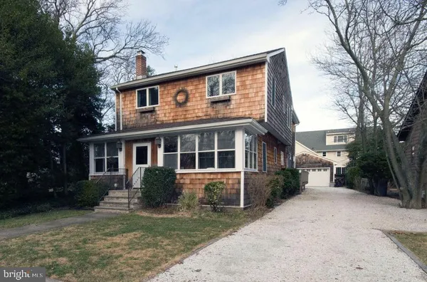 a front view of a house with a yard and trees