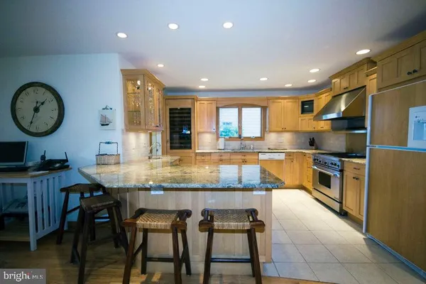 a kitchen with granite countertop kitchen island stainless steel appliances a table and chairs
