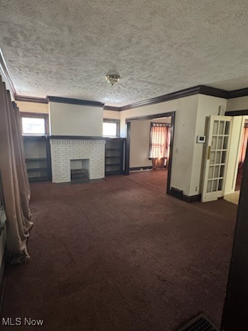 870 Helmsdale Road Cleveland Heights, OH 44112 - Photo 6 of 20 Unfurnished living room with crown molding, dark carpet, a textured ceiling, and a brick fireplace