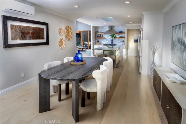 a kitchen with stainless steel appliances wooden floor dining table and chairs