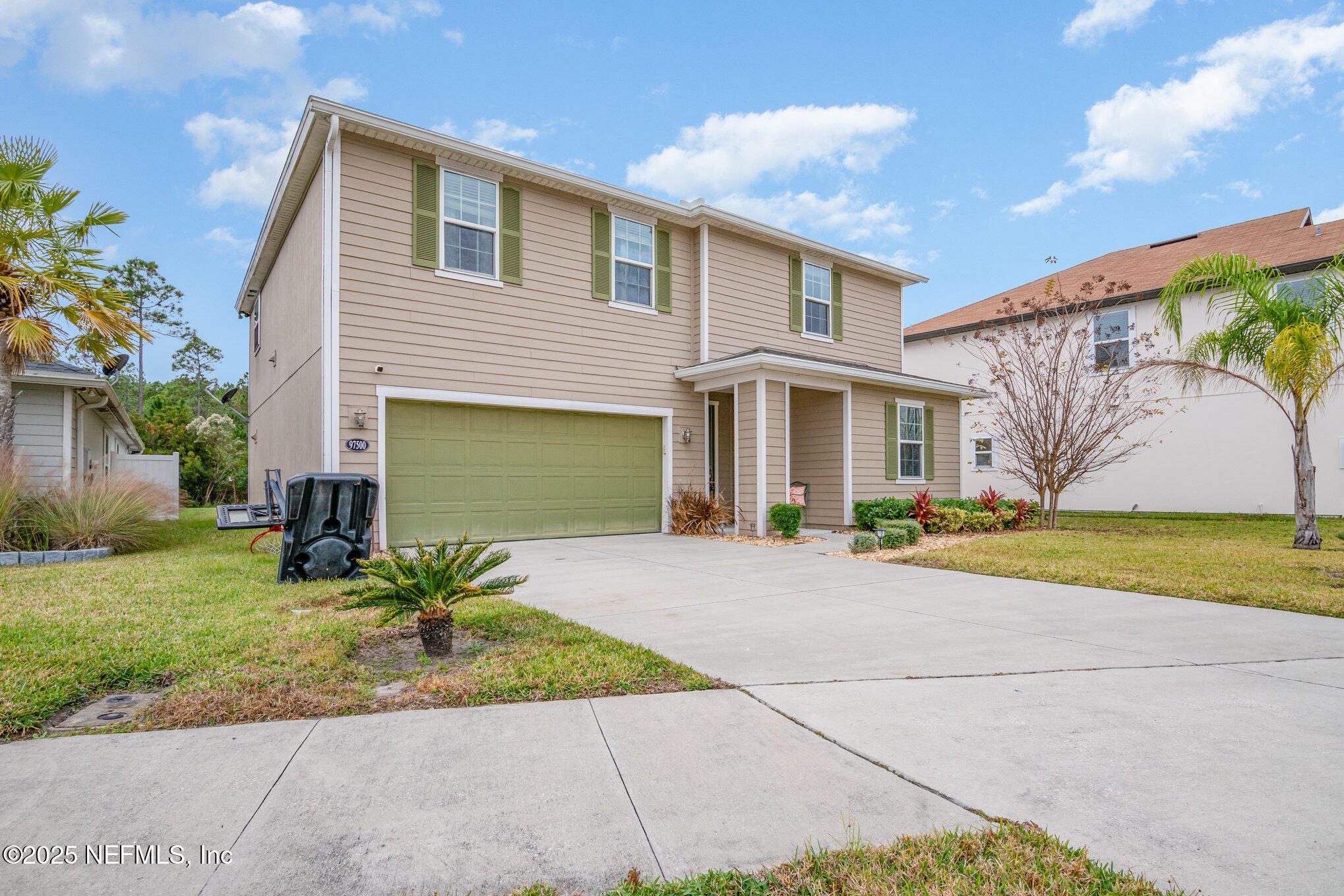 97500 Albatross Drive Yulee, FL 32097 - Photo 2 of 28 a front view of a house with a yard and a garage