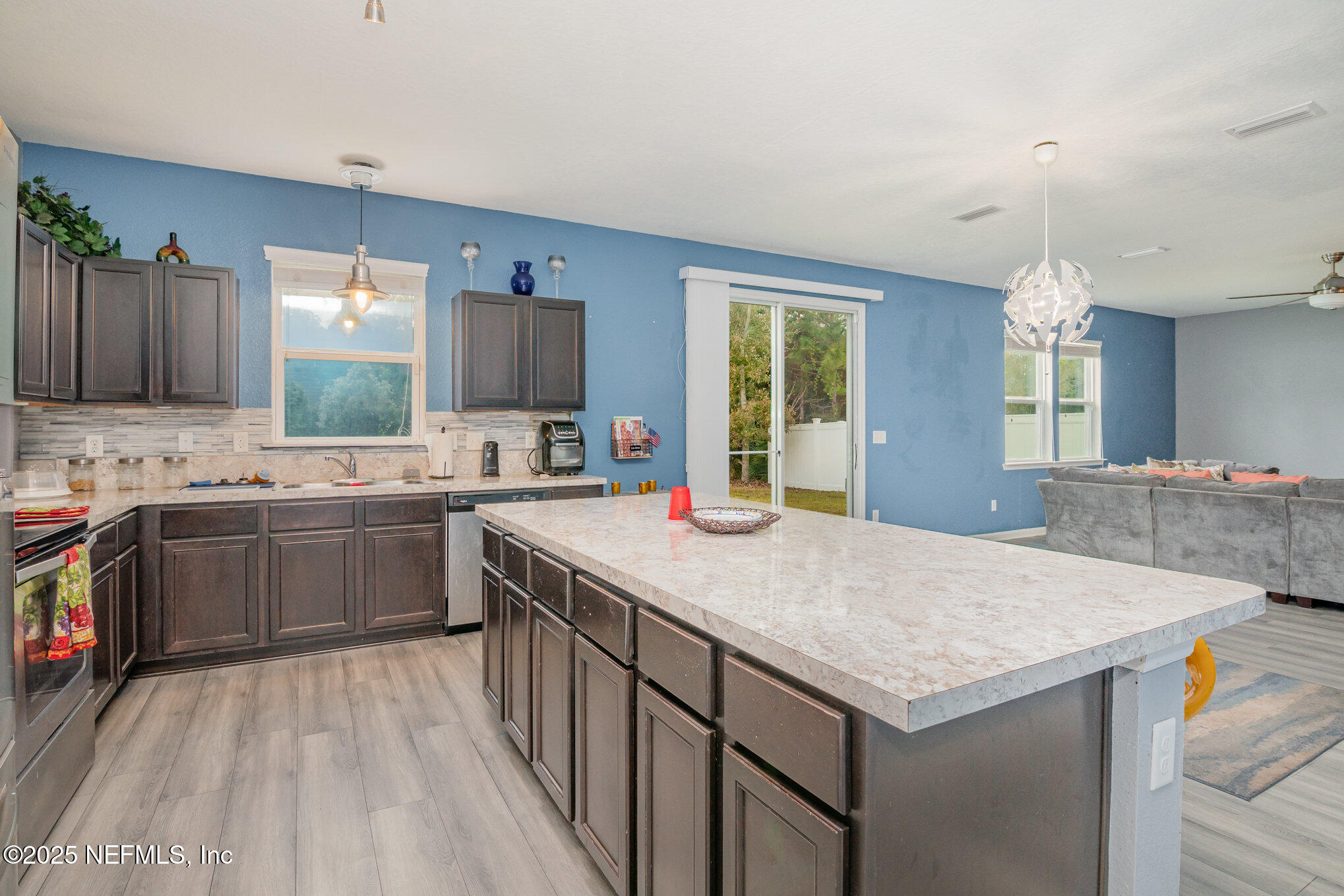 97500 Albatross Drive Yulee, FL 32097 - Photo 9 of 28 a kitchen that has a sink a stove and a wooden cabinets