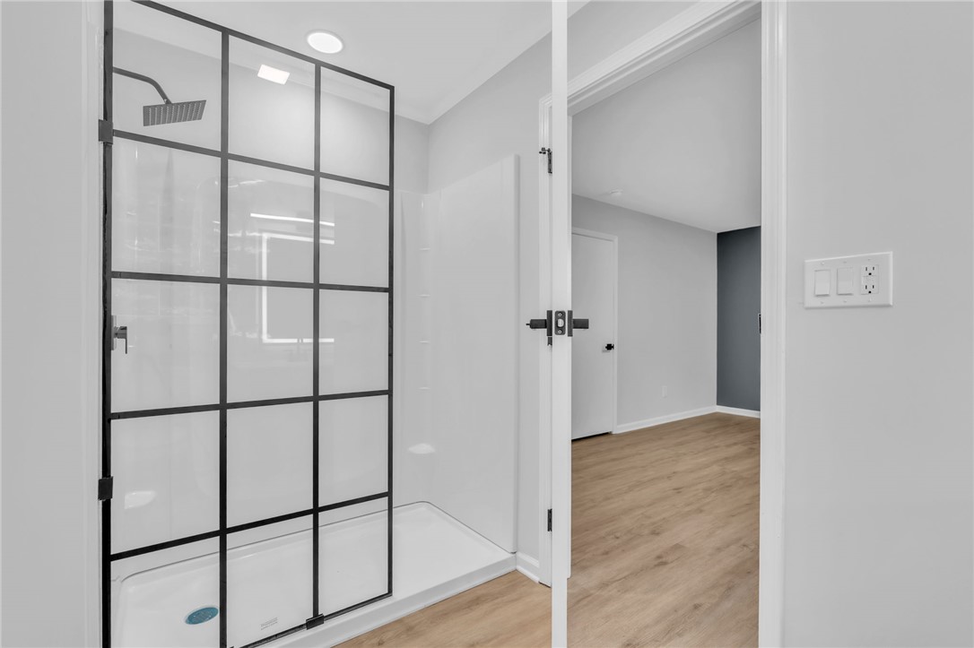 403 Keith Lane Seneca, SC 29678 - Photo 15 of 28 Modern shower with sleek black framing and a rain showerhead complements the light wood-look flooring.