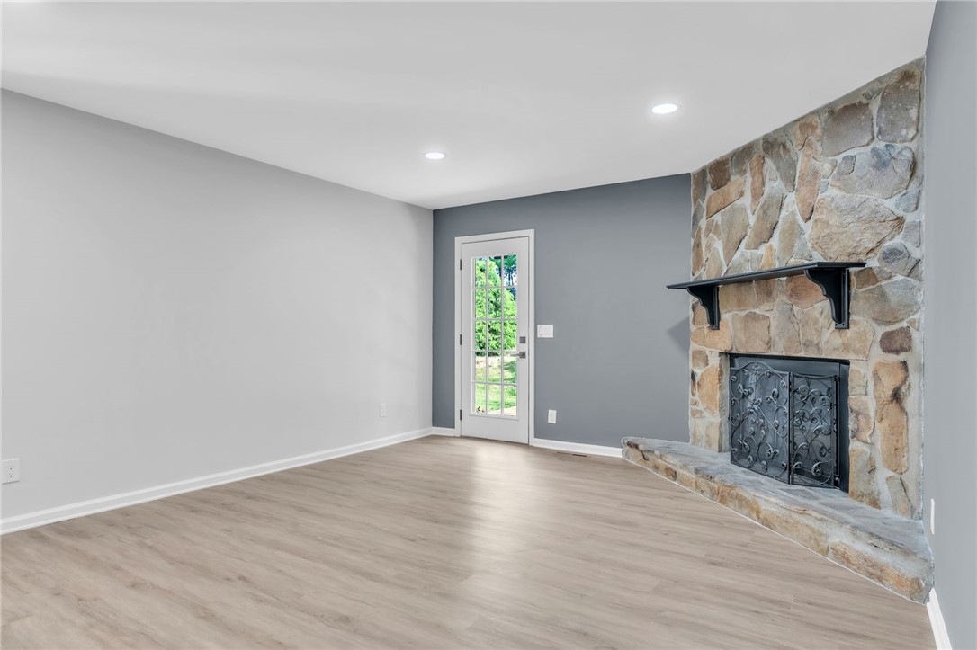 403 Keith Lane Seneca, SC 29678 - Photo 8 of 28 This inviting living space features warm wood flooring and a classic stone fireplace.