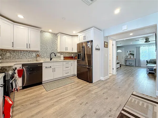 a kitchen with appliances a sink and cabinets