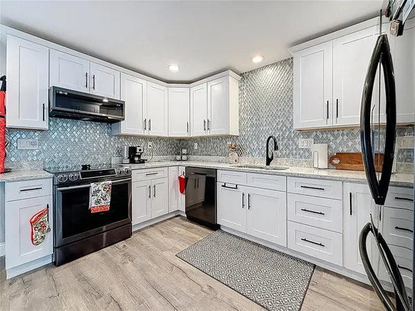a kitchen with stainless steel appliances granite countertop a sink stove and cabinets