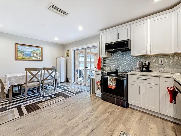 a large kitchen with kitchen island a dining table and chairs