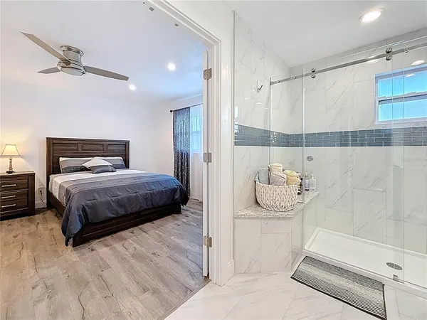 a spacious bedroom with a bed and a flat screen tv