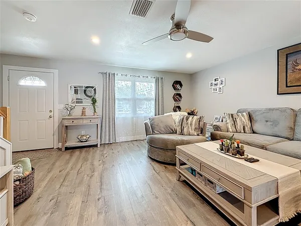 a living room with furniture and a wooden floor