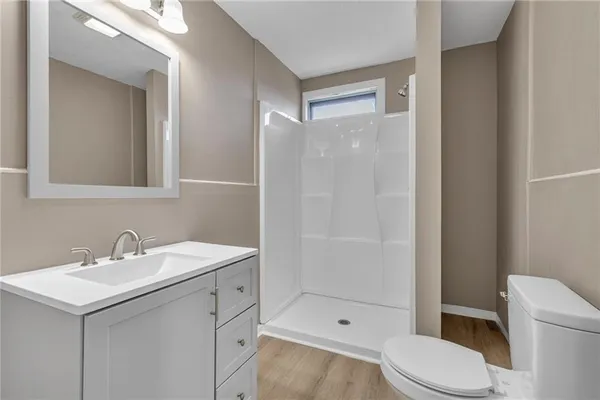 a bathroom with a sink toilet vanity and shower