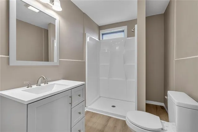 a bathroom with a sink toilet vanity and shower