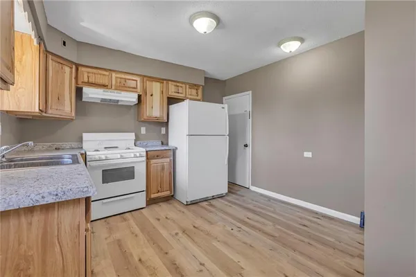 a kitchen with a white stove top oven and refrigerator
