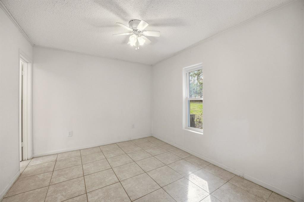216 Broken Arrow Comanche, TX 76442 - Photo 16 of 38 an empty room with windows and fan