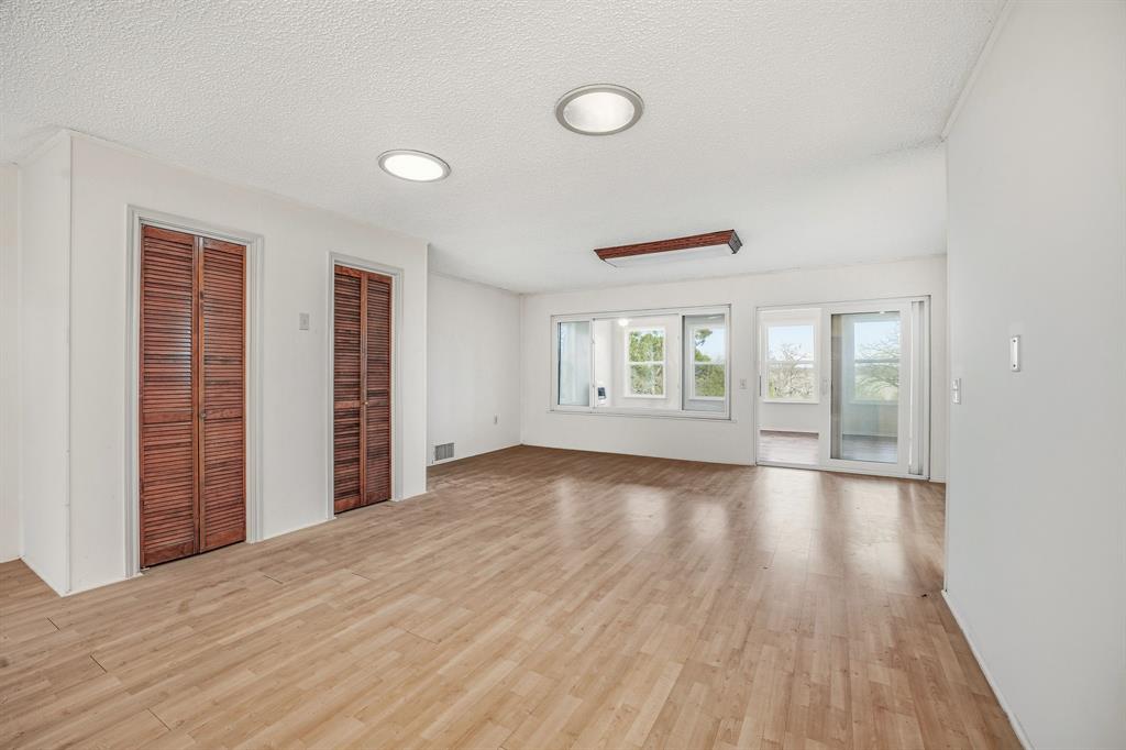 216 Broken Arrow Comanche, TX 76442 - Photo 24 of 38 an empty room with wooden floor and windows