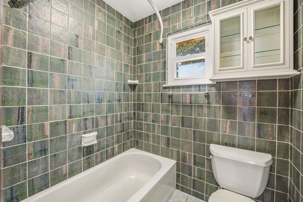 216 Broken Arrow Comanche, TX 76442 - Photo 26 of 38 a bathroom with a bathtub a window and a shower