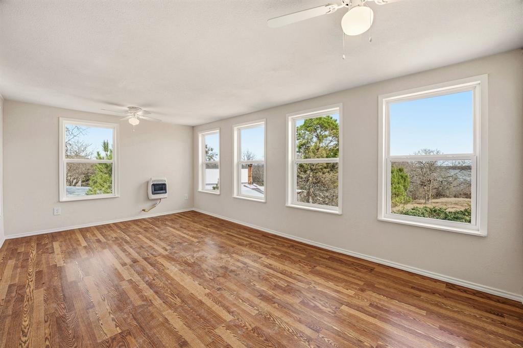 216 Broken Arrow Comanche, TX 76442 - Photo 27 of 38 a view of an empty room with wooden floor and a window