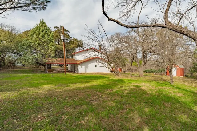 a view of a large building with yard and trees around