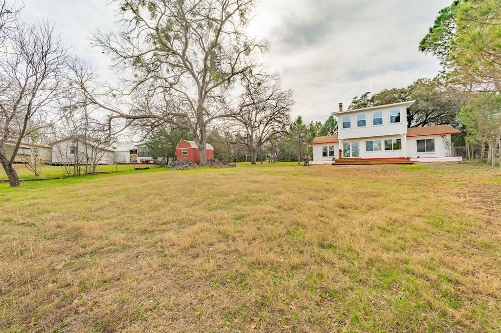 216 Broken Arrow Comanche, TX 76442 - Photo 8 of 38 a view of a large building with yard and trees around