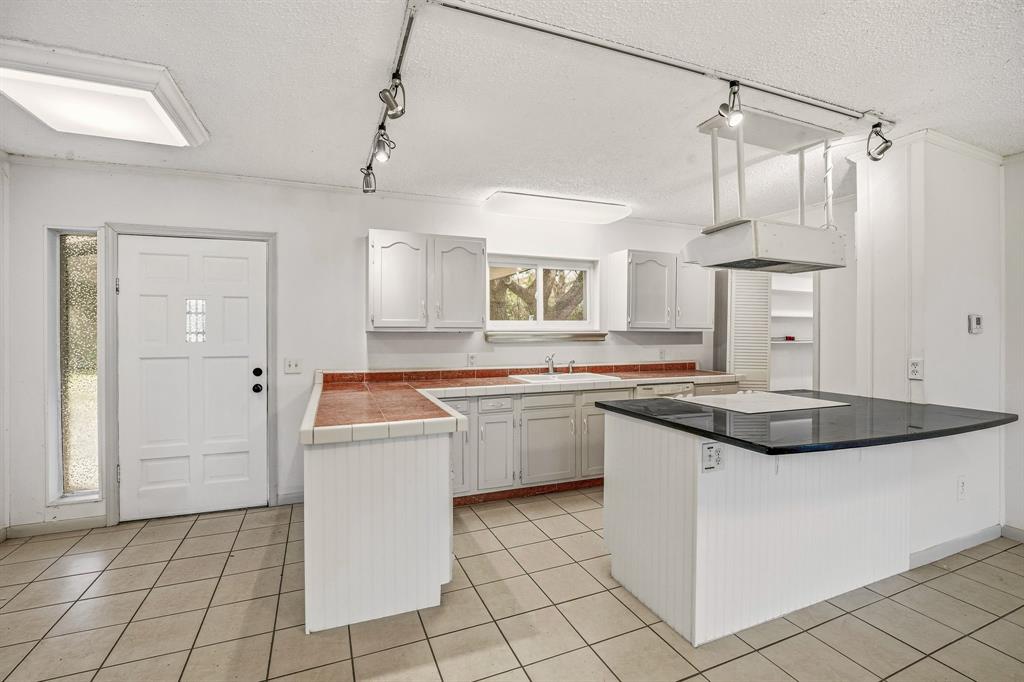 216 Broken Arrow Comanche, TX 76442 - Photo 10 of 38 a kitchen with a sink and cabinets