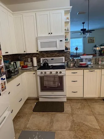 a kitchen with stainless steel appliances granite countertop a sink a stove and cabinets