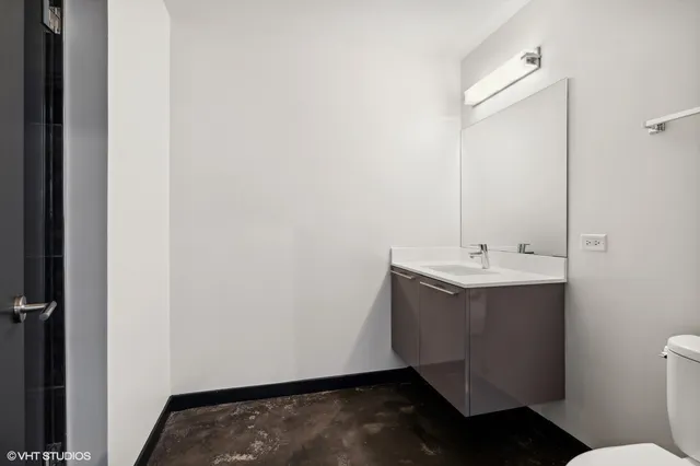 a bathroom with a sink and mirror with toilet