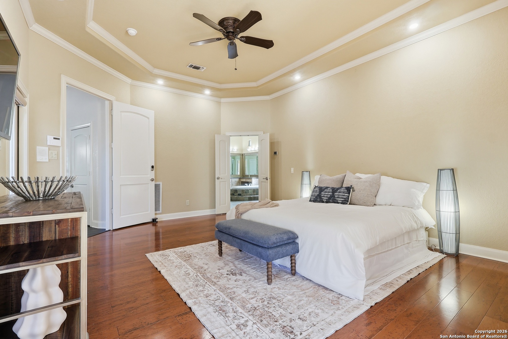 2435 Winding View San Antonio, TX 78260 - Photo 30 of 57 a spacious bedroom with a bed a mirror and wooden floor