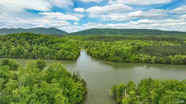 an aerial view of residential houses with outdoor space and lake view