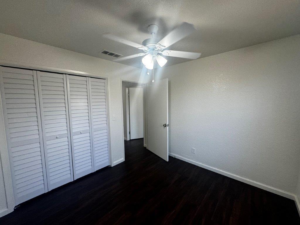 1405 East Cypress Avenue Reedley, CA 93654 - Photo 19 of 29 an empty room with wooden floor and fan
