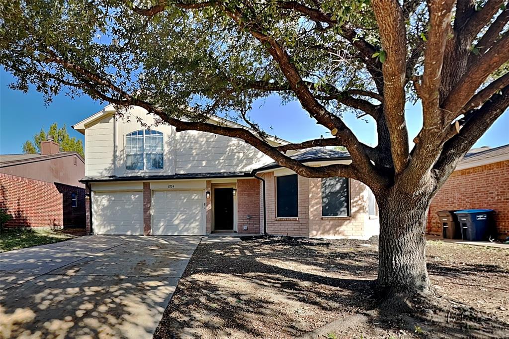 View of front of property featuring brick siding, concrete driveway, and an attached garage