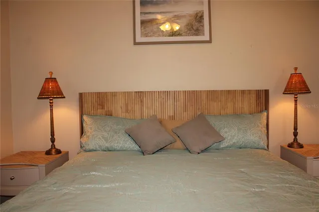 a bed sitting in a room next to a lamp