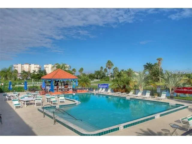 a view of a swimming pool with lawn chairs under an umbrella