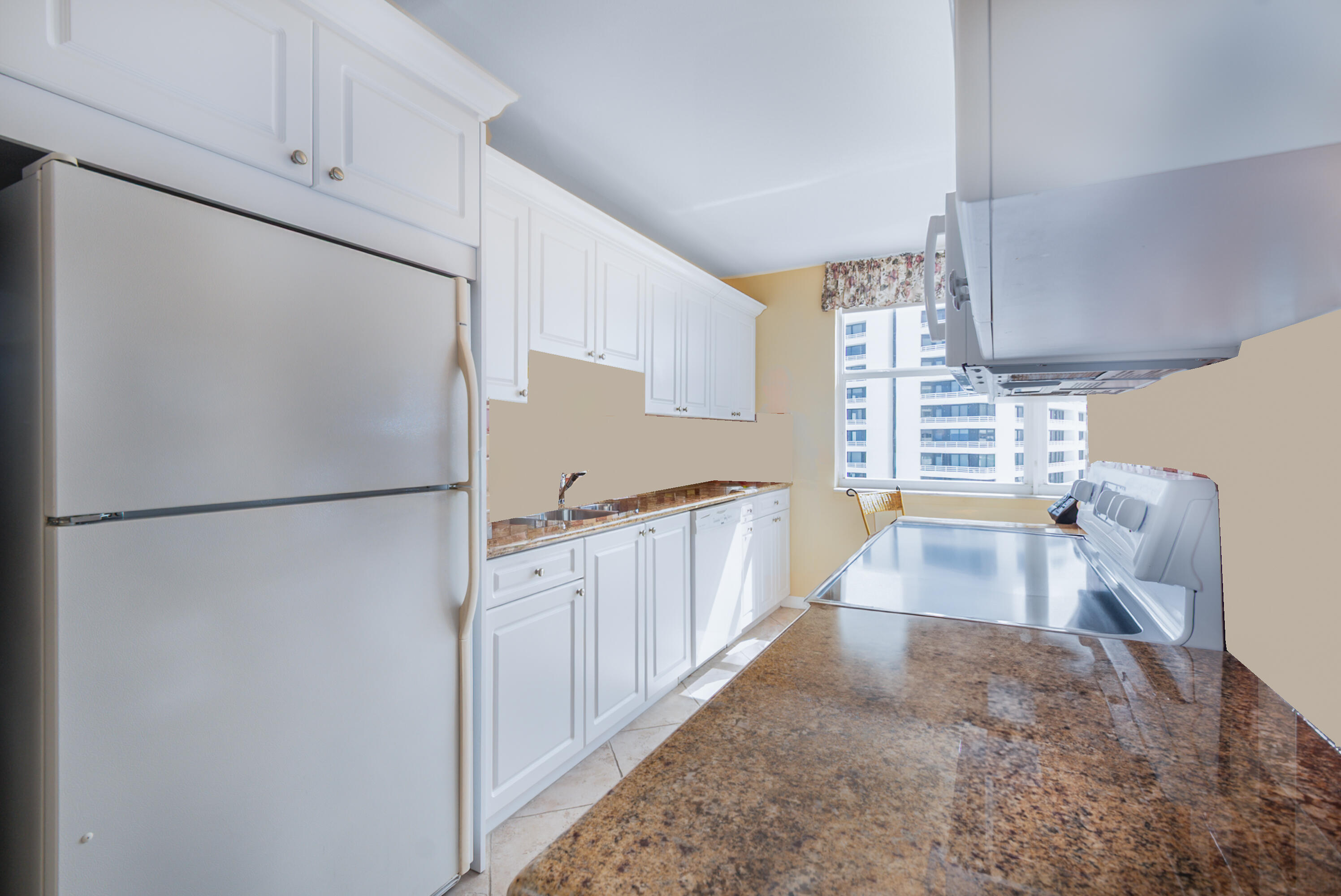 1200 South Ocean Boulevard, Unit 11D Boca Raton, FL 33432 - Photo 11 of 45 a white refrigerator freezer sitting inside of a kitchen