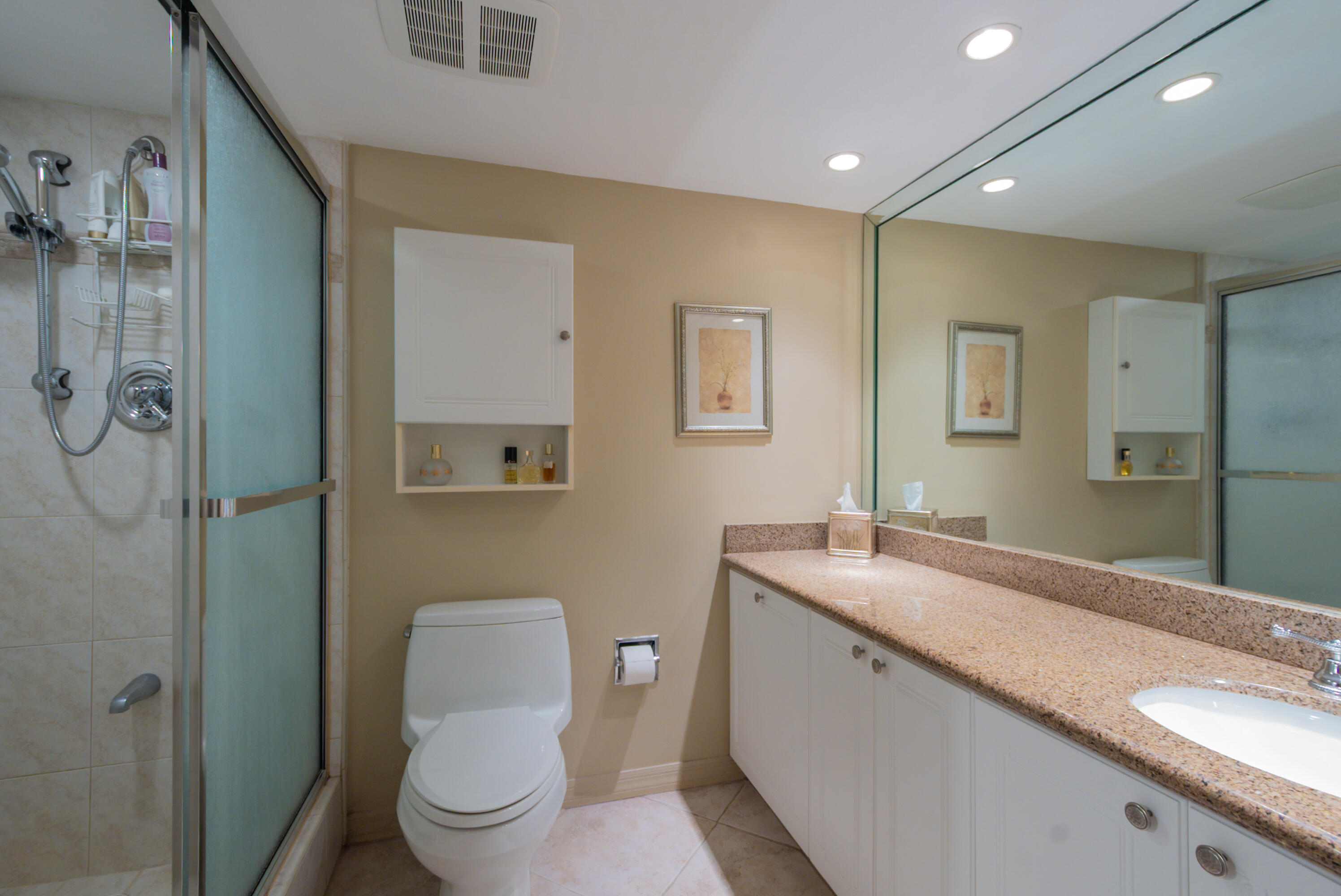 1200 South Ocean Boulevard, Unit 11D Boca Raton, FL 33432 - Photo 7 of 45 a bathroom with a granite countertop sink a toilet and a mirror