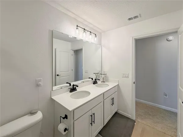 a bedroom with a bed and a large mirror