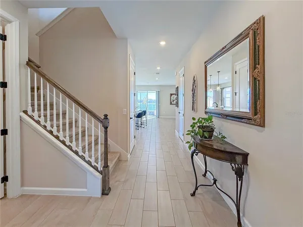 a kitchen with stainless steel appliances kitchen island granite countertop a refrigerator a stove a sink a dining table and chairs with wooden floor