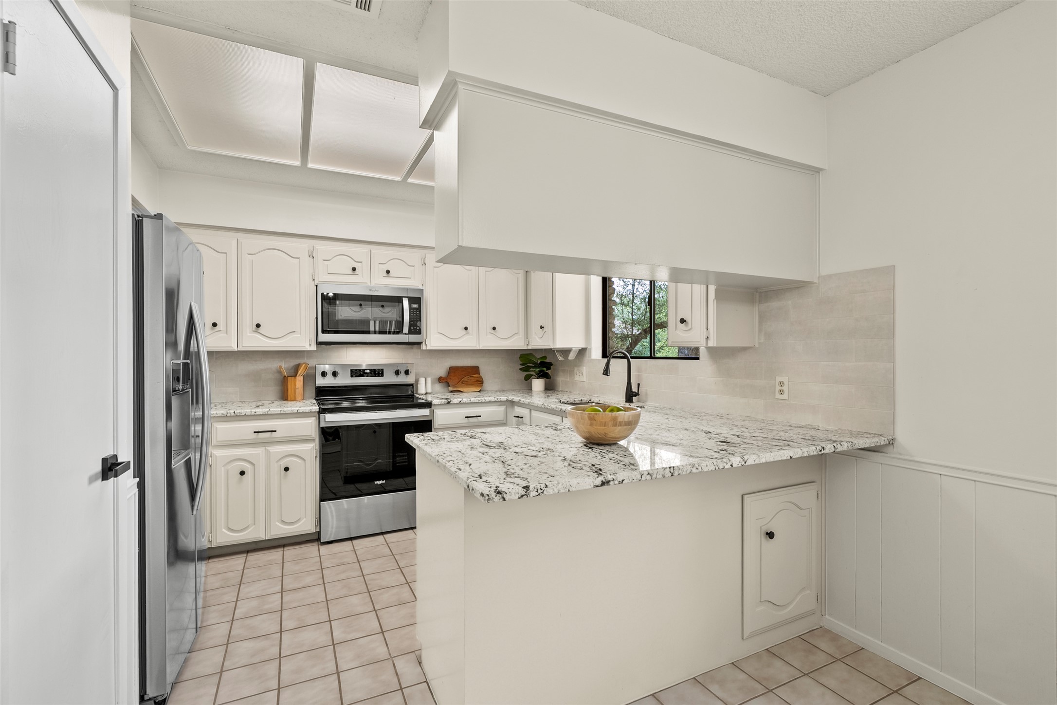 303 West Sequoia Spur Georgetown, TX 78628 - Photo 10 of 34 a kitchen with stainless steel appliances granite countertop a sink dishwasher stove top oven and white cabinets