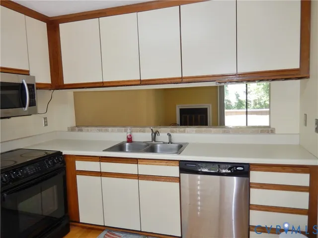 a kitchen with stainless steel appliances granite countertop a sink a stove and a microwave