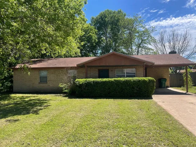 a front view of a house with yard and green space