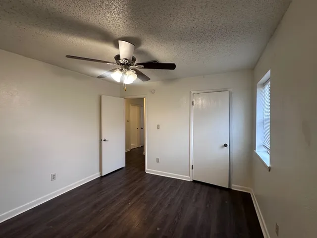 a view of an empty room with wooden floor