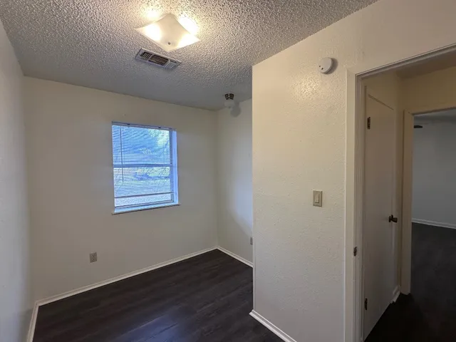 a view of a room with wooden floor and a window