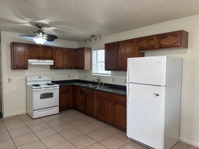 a kitchen with a white stove top oven and refrigerator